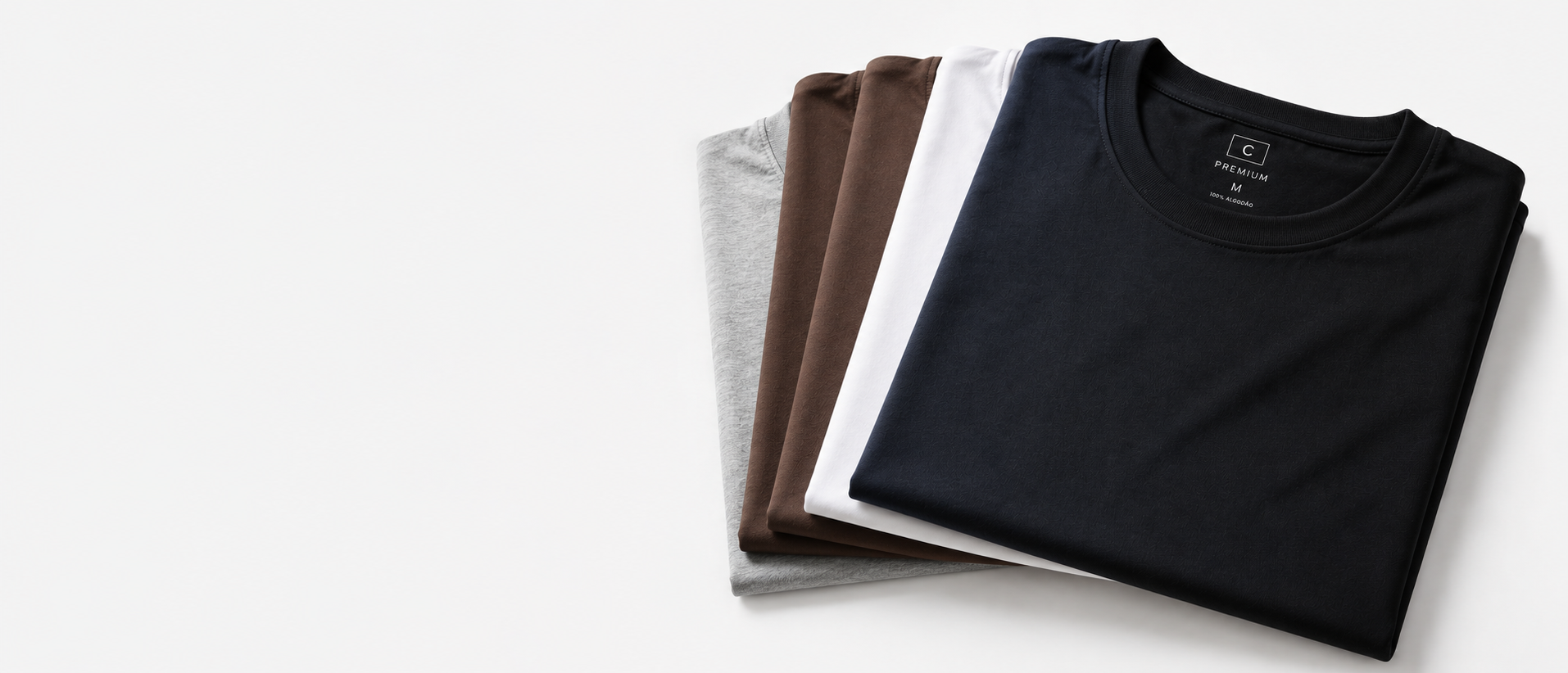 Camisetas premium Camisetorama em diferentes cores, dobradas sobre fundo neutro